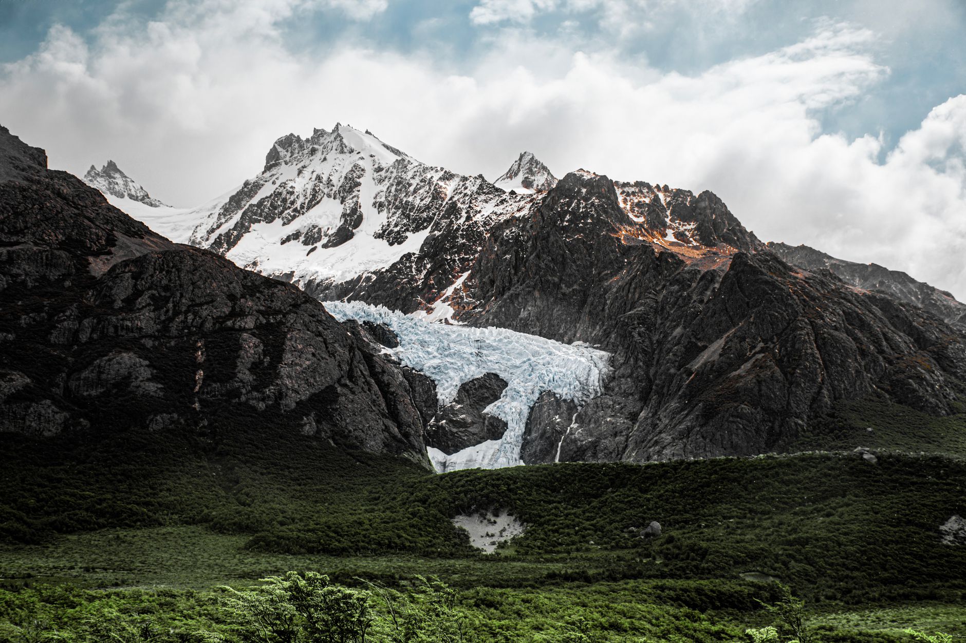 Glacial mountain range with jagged peaks shrouded in mist